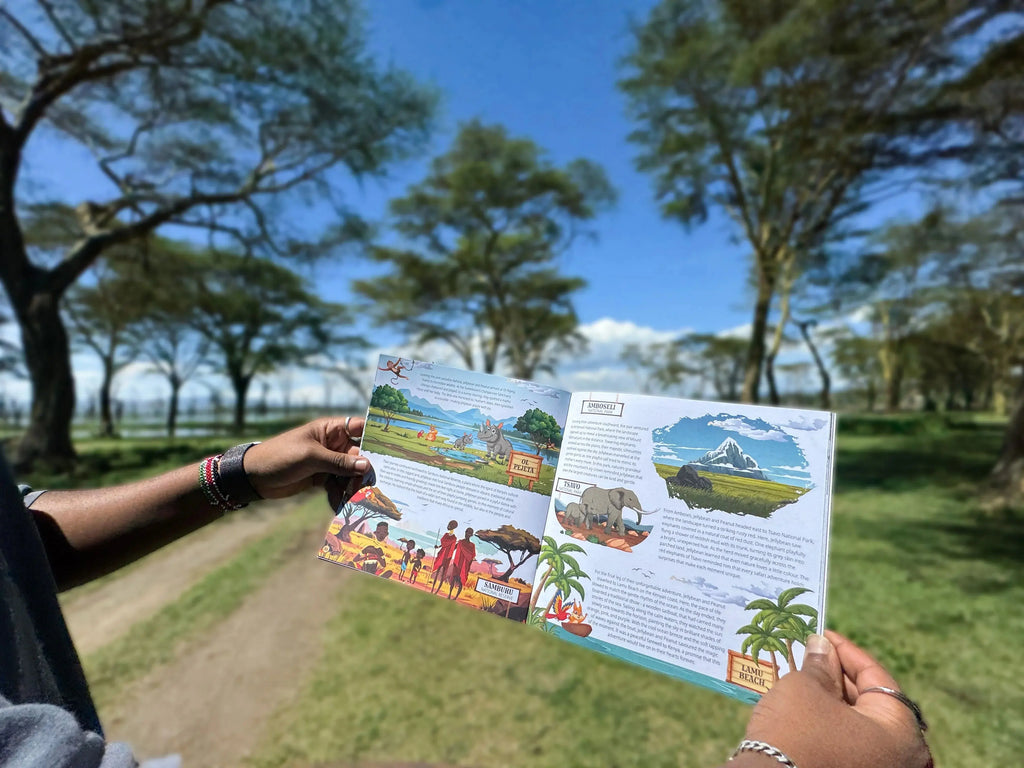 Person holding an open book with illustrated scenes of a safari, trees, and people in a natural setting.